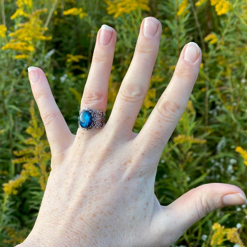 Antiqued silver filigree adjustable ring with blue shell.