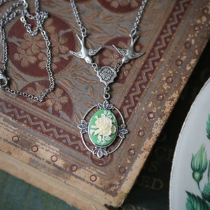 Elizabethan vintage fashion inspired Irish green and cream flower bunch cameo casual chic necklace.  Avian couture featuring two free flying swallows holding up the pendant.