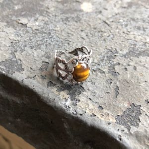 Antiqued silver filigree adjustable rings in vintage style with a tiger's eye cabochon set on a bezel.