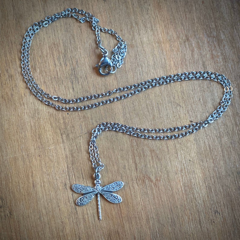 Dainty silver dragonfly necklace on 18 inches of chain.