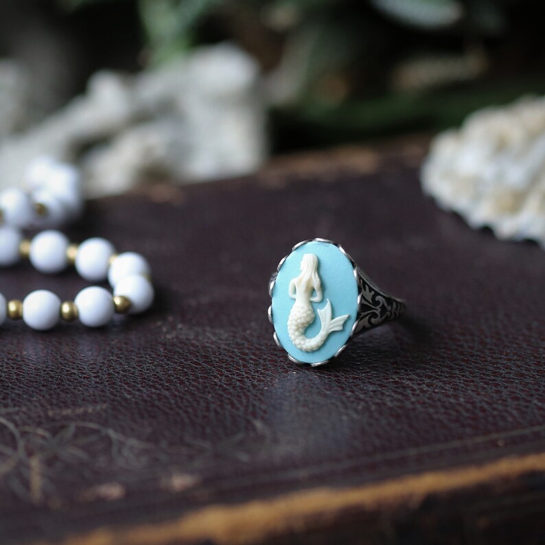 Antiqued silver adjustable vintage style ring with a Light blue and white mermaid cameo.
