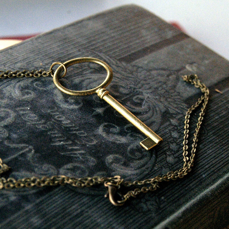 Antiqued brass oval skeleton key pendant necklace in vintage style.