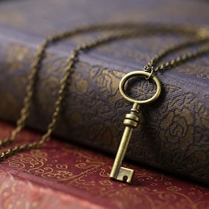 Small brass oval skeleton key pendant necklace in vintage style.