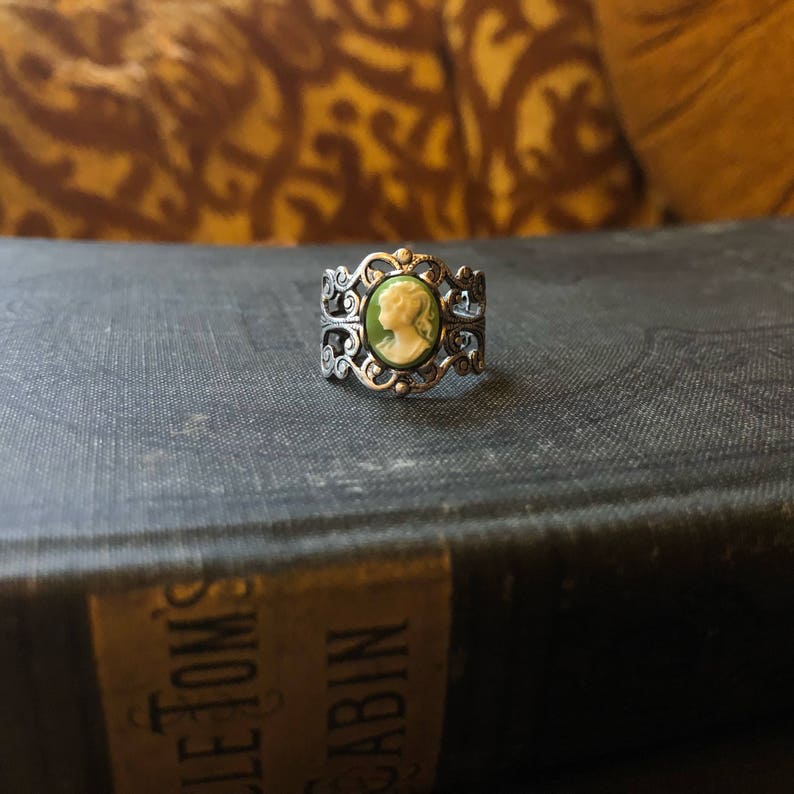 Antiqued silver adjustable filigree ring in vintage-style with a green and cream small lady cameo set on a bezel.