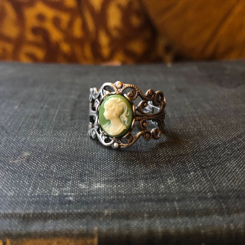 Antiqued silver adjustable filigree ring in vintage-style with a green and cream small lady cameo set on a bezel.