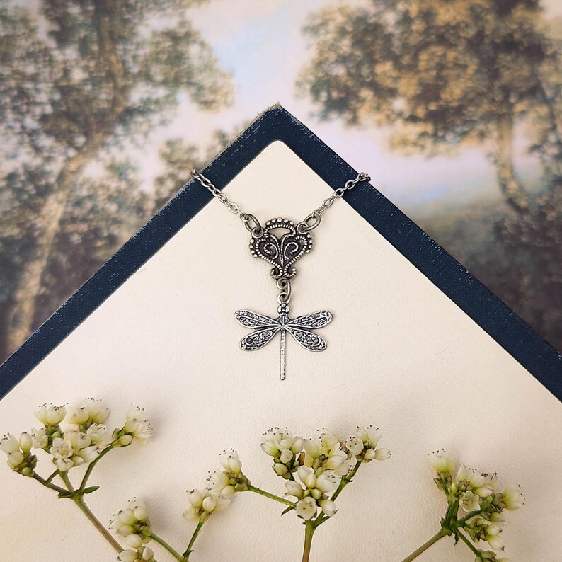 Antiqued silver filigree small dragonfly necklace in vintage syle on a chain with a connector.