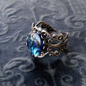 Antiqued silver filigree adjustable ring with blue shell.