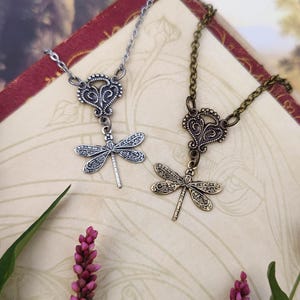 Antiqued brass or silver filigree small dragonfly necklaces in vintage-syle on a chain with a connector compared side by side.