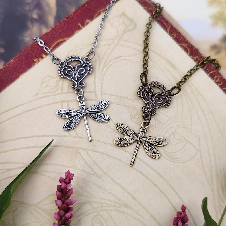 Antiqued brass or silver filigree small dragonfly necklaces in vintage-syle on a chain with a connector compared side by side.