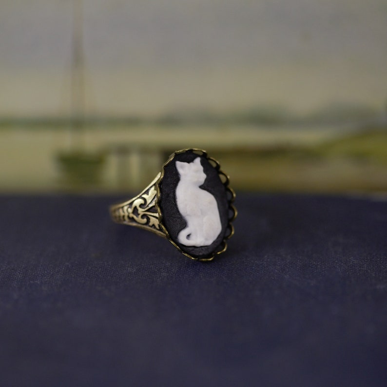 Antiqued brass vintage style adjustable ring with a black and white cat cameo.