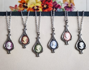 May include: Six silver necklaces with cameo pendants. The cameos are in various colors, including pink, blue, green, and black.