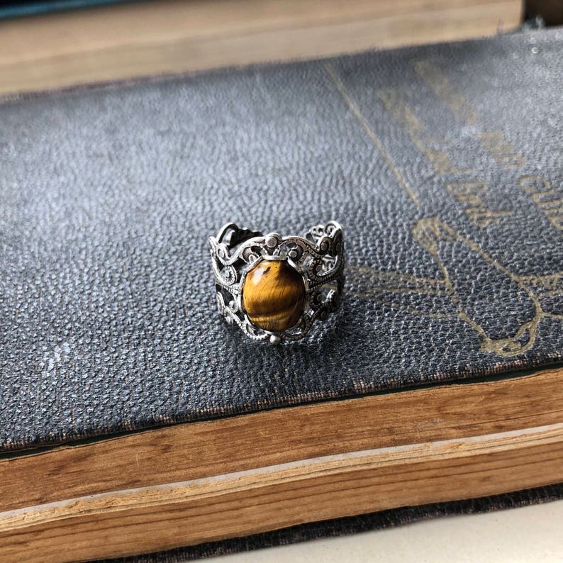 Antiqued silver filigree adjustable rings in vintage style with a tiger's eye cabochon set on a bezel.