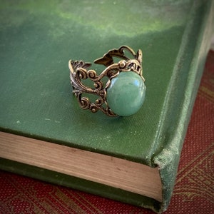 Sage green aventurine stone mineral cabochon on and antiqued brass adjustable filigree ring in vintage=style.