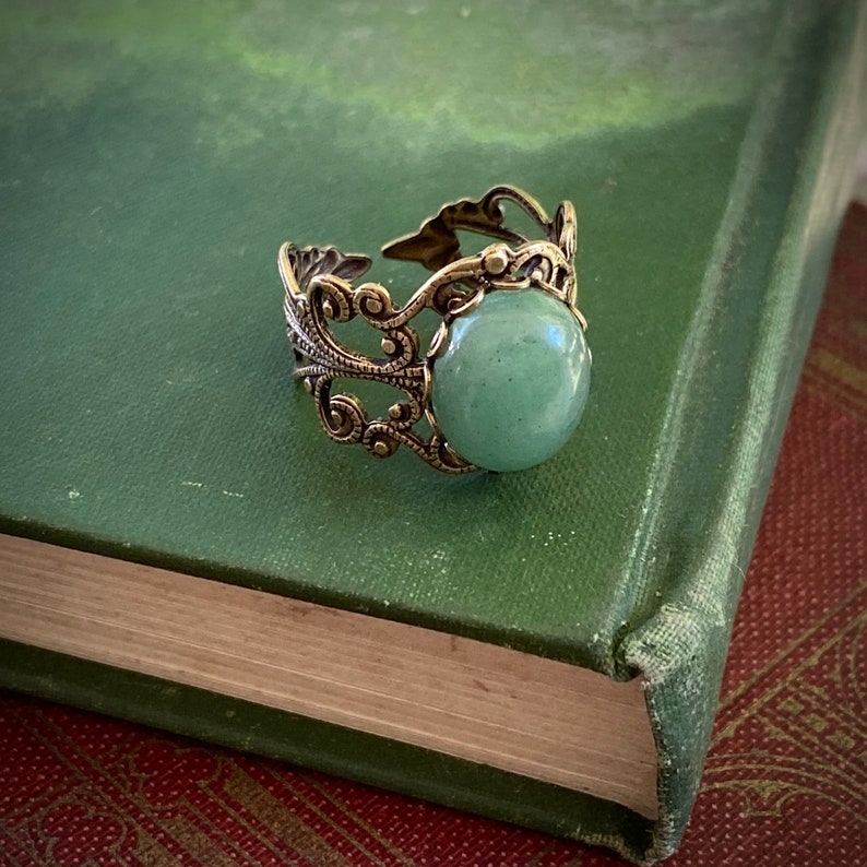 Sage green aventurine stone mineral cabochon on and antiqued brass adjustable filigree ring in vintage=style.