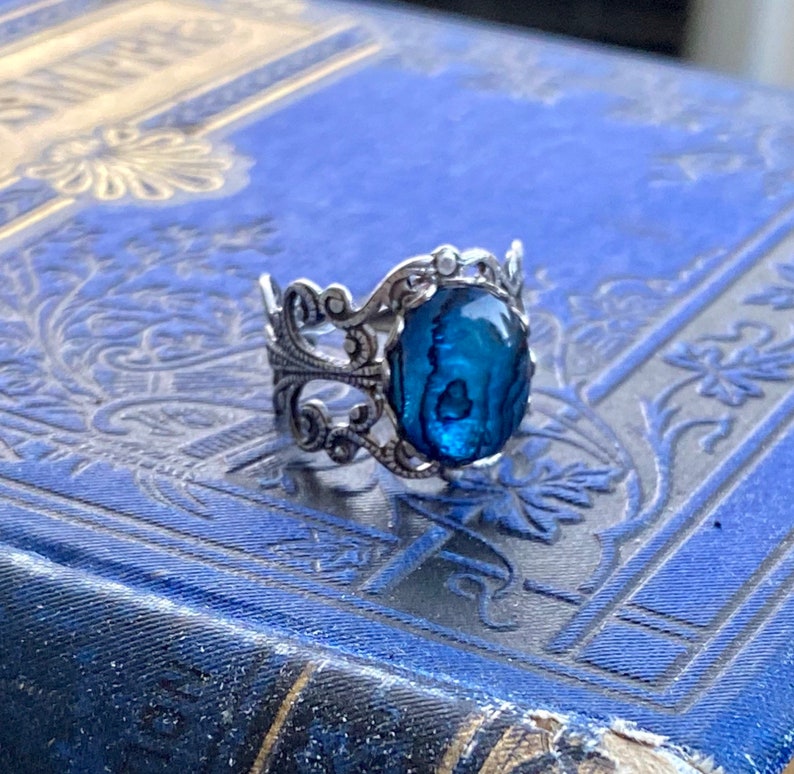 Antiqued silver filigree adjustable ring with blue shell.