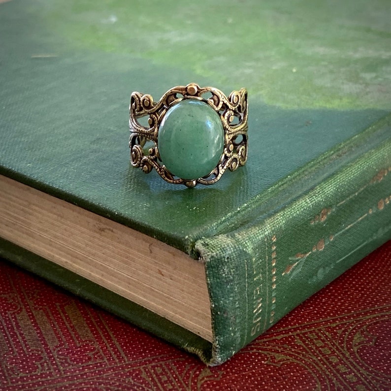 Sage green aventurine stone mineral cabochon on and antiqued brass adjustable filigree ring in vintage=style.