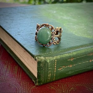 Sage green aventurine stone mineral cabochon on and antiqued brass adjustable filigree ring in vintage=style.