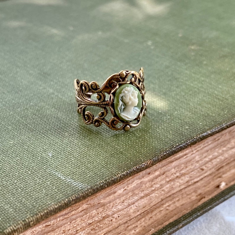 Antiqued brass and silver adjustable filigree ring in vintage-style with a green and cream small lady cameo set on a bezel.