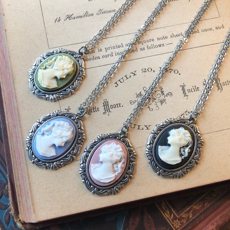 Lady cameo necklaces in antiqued silver vintage style settings.  Available in green and cream, blue and white, pink or black.