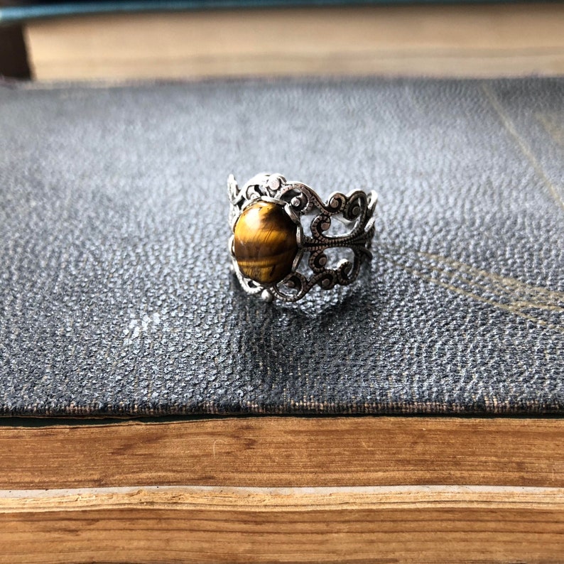 Antiqued silver filigree adjustable rings in vintage style with a tiger's eye cabochon set on a bezel.