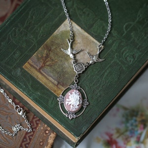 Long Victorian aesthetic unique necklace with elegant bloomcore floral cameo in mauve and white with an antiqued silver plant inspired setting held up by two sparrows or nightingale.  Nature core bridesmaids' necklace.