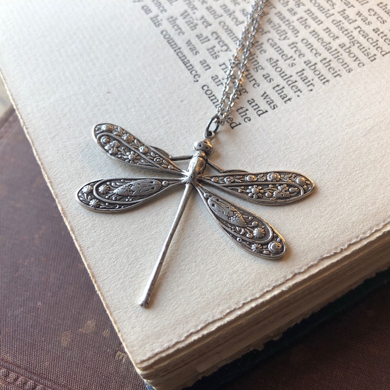 Floral motif dragonfly pendant necklace in antiqued silver.