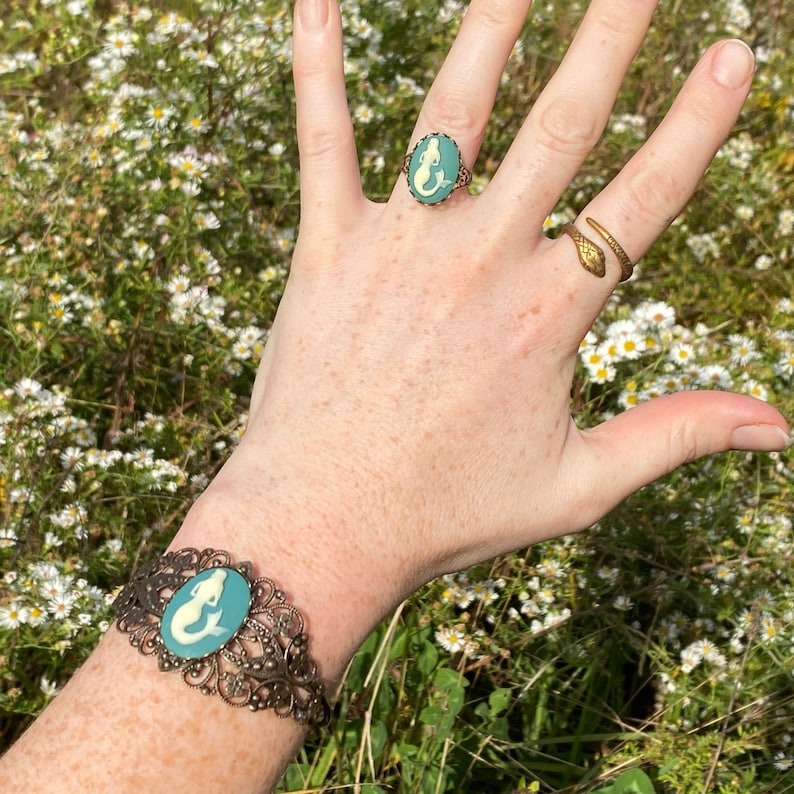 Antiqued brass adjustable vintage style ring with a blue and cream mermaid cameo with matching cuff bracelet.