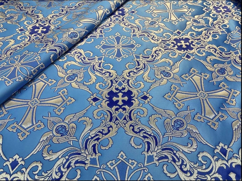 May include: Blue fabric with a gold and blue cross pattern. The fabric has a brocade texture and is perfect for upholstery or crafts.