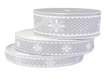 May include: Three rolls of decorative ribbon in shades of gray and white. The ribbon features a repeating pattern of diamond shapes and crosses. The rolls are stacked on top of each other, with the top roll fully visible.