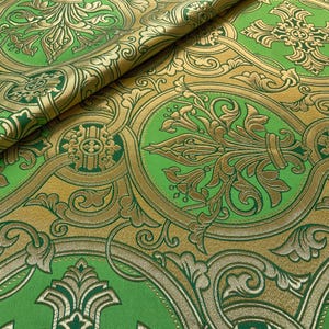 May include: Green and gold fabric with a damask pattern. The fabric has a raised texture and a luxurious feel.