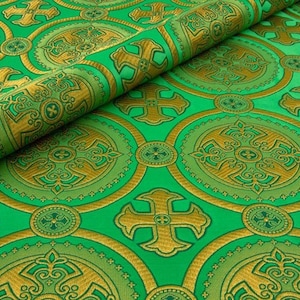 May include: Green fabric with a repeating pattern of gold crosses in circles. The fabric has a subtle sheen and a luxurious feel.