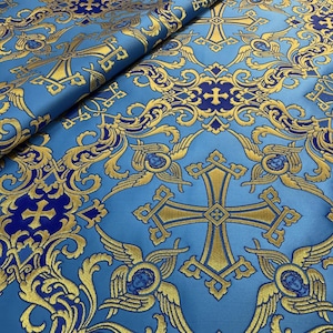 May include: Blue fabric with a gold and blue pattern of crosses and angels. The fabric has a brocade texture.