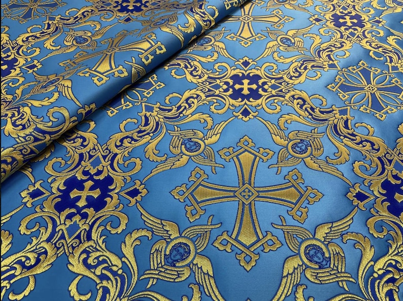 May include: Blue fabric with a gold and blue pattern of crosses and angels. The fabric has a brocade texture.