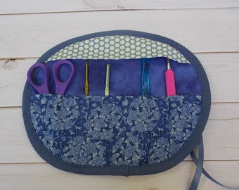 Estuche de viaje enrollable de tela azul para ganchos de crochet, organizador para guardar y organizar manualidades.