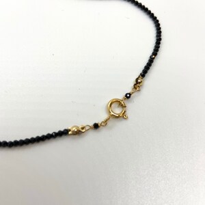 May include: A black beaded bracelet with a gold clasp.