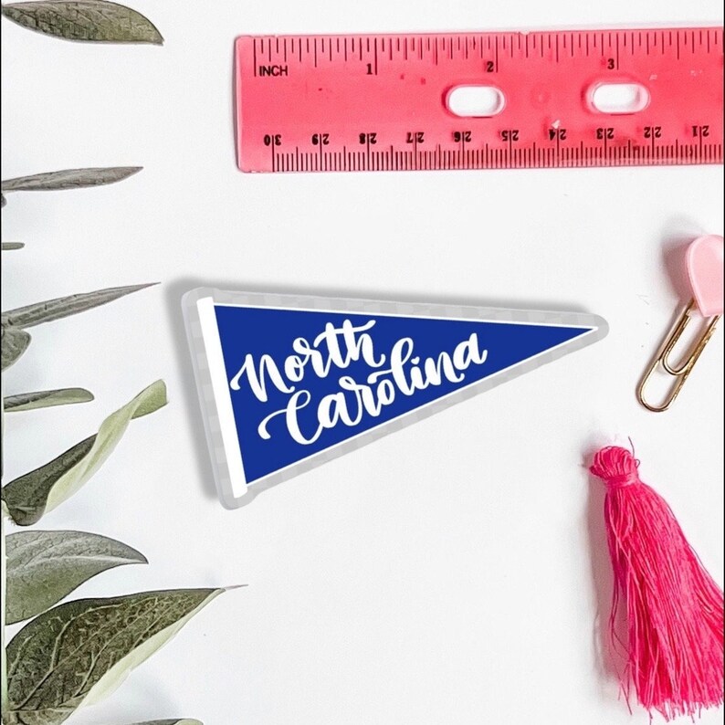 May include: A blue pennant with white text that reads "North Carolina".