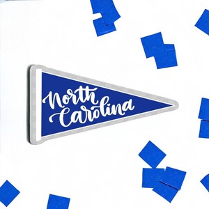May include: A blue pennant with white text that reads "North Carolina".