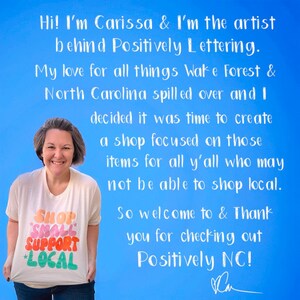 May include: A woman wearing a white t-shirt with the text "Shop Small Support Local" in colourful letters, smiles at the camera. The background is a light blue with white text that reads "Hi! I'm Carissa & I'm the artist behind Positively Lettering. My love for all things Wake Forest & North Carolina spilled over and I decided it was time to create a shop focused on those items for all y'all who may not be able to shop local. So welcome to & Thank you for checking out Positively NC!"