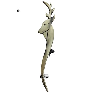 May include: A gold-toned metal door handle shaped like a deer head with antlers. The handle is curved and has a detailed design.