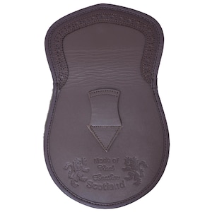 May include: Brown leather kilt sporran with a decorative stitched design and the text "Made of Real Leather Scotland".
