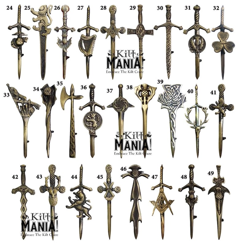 May include: A collection of 49 different kilt pins, each featuring a unique design. The pins are made of metal and have a gold finish. The designs include various Scottish symbols, such as thistles, swords, and crests. The pins are numbered from 24 to 49.