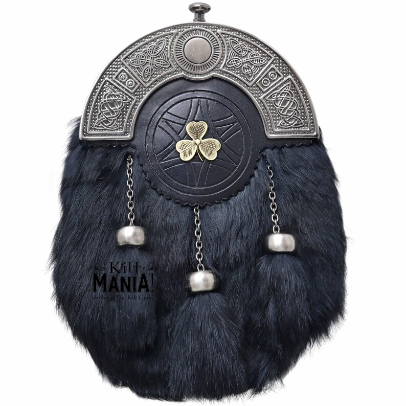 Puede incluir: Un sporran escoc&eacute;s tradicional con un cuerpo de piel oscura y una parte superior de metal decorativa. El sporran presenta una parte delantera de cuero negro con un emblema de tr&eacute;bol dorado. Cadenas y borlas plateadas cuelgan de la parte inferior.
