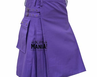 Puede incluir: Un kilt morado liso con pliegues, bolsillos y correas ajustables. El kilt tiene dos hebillas y un cierre de botón. El texto "Kilt MANIA!" es visible. Esta prenda tradicional está hecha de una tela duradera.