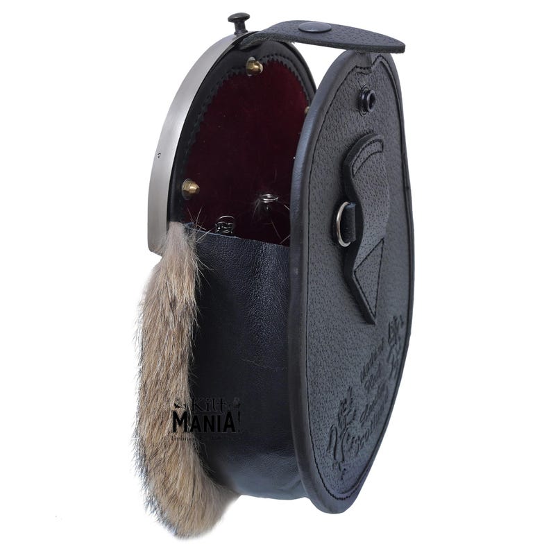 May include: A black leather sporran with a fur trim and a silver metal clasp. The sporran is open and the inside is lined with red velvet.