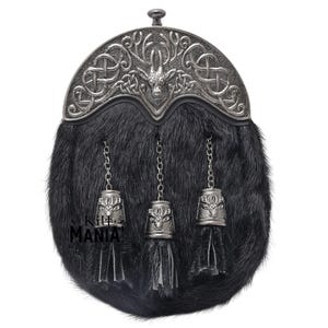 May include: A black fur sporran with a silver metal top featuring a Celtic knot design and a stag head. The sporran has three silver tassels with chains.