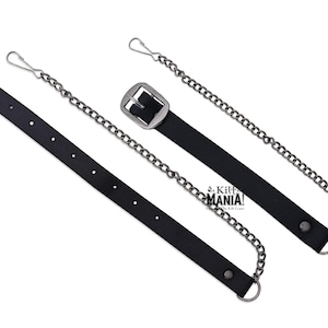 May include: A black leather strap with a silver buckle and a silver chain attached. The strap has a silver hook on one end and a silver loop on the other end.