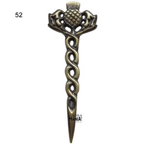 May include: A gold-toned metal kilt pin with a thistle design. The pin is shaped like a sword with a twisted handle and a pointed tip. The thistle is detailed with a textured surface and a small stem.