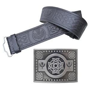 May include: A black leather belt with embossed Celtic knot and thistle designs. The silver-colored buckle features a central Celtic knot design, surrounded by thistle motifs and decorative patterns. A traditional accessory.