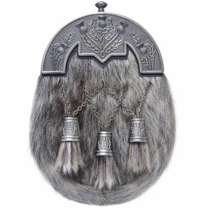 Peut inclure: Un sporran écossais traditionnel avec un corps en fourrure grise et un cantle en métal argenté. Le cantle est orné de chardons et de motifs de nœuds celtiques. Trois glands argentés pendent du bas, ajoutant à l'attrait décoratif du sporran.