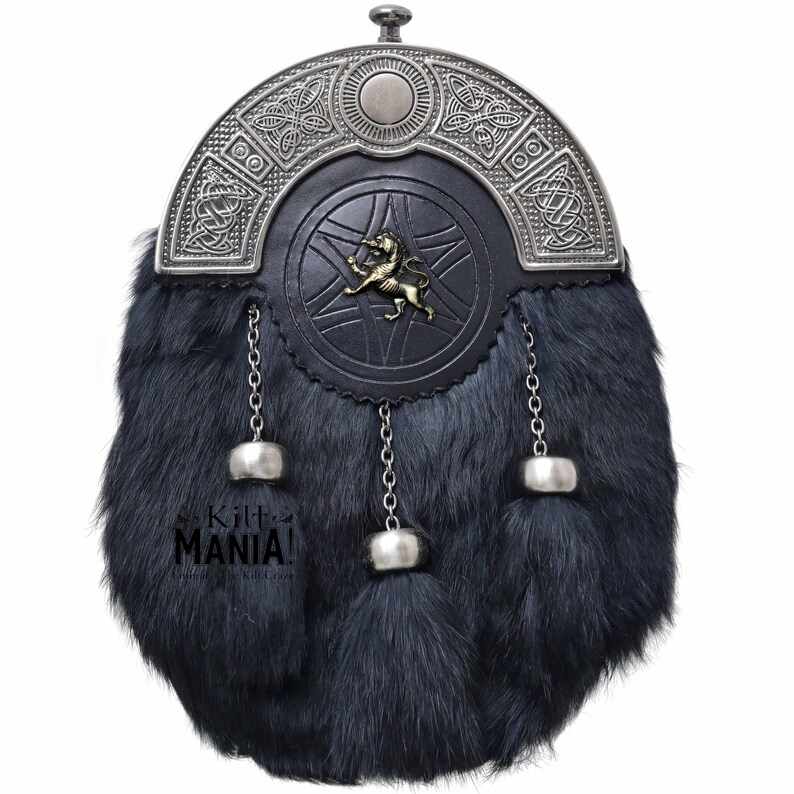Puede incluir: Un sporran de piel negra con una parte superior de metal plateado y una parte delantera de cuero negro. La parte delantera presenta un emblema de le&oacute;n y dise&ntilde;os de nudos celtas. Cadenas y borlas plateadas cuelgan de la parte inferior. El texto "Kilt MANIA!" es visible.